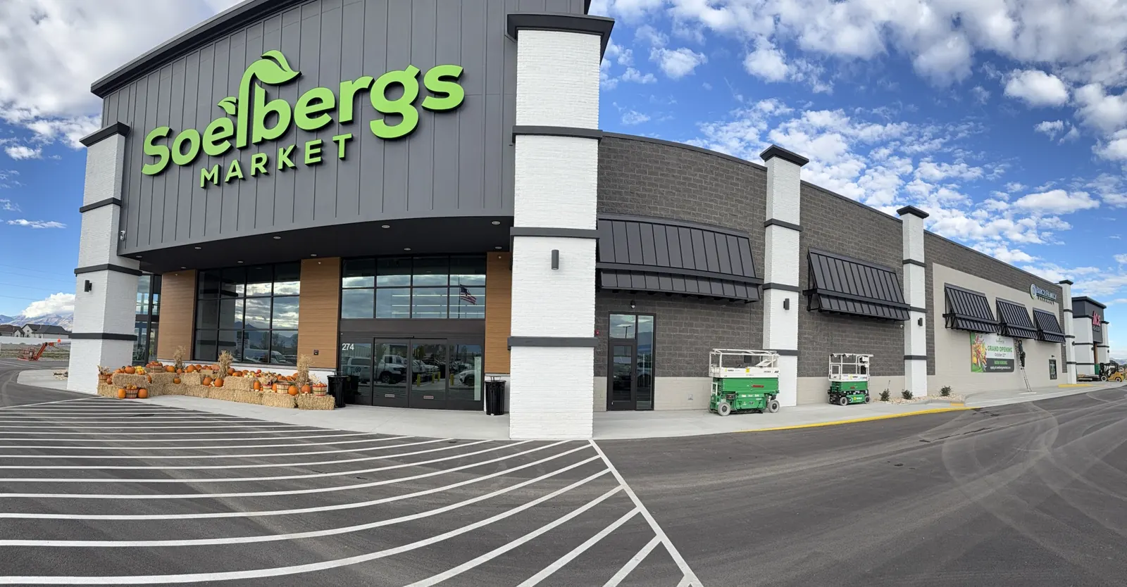 Wide view of the Soelbergs Market storefront, with scissor lifts parked along the wall